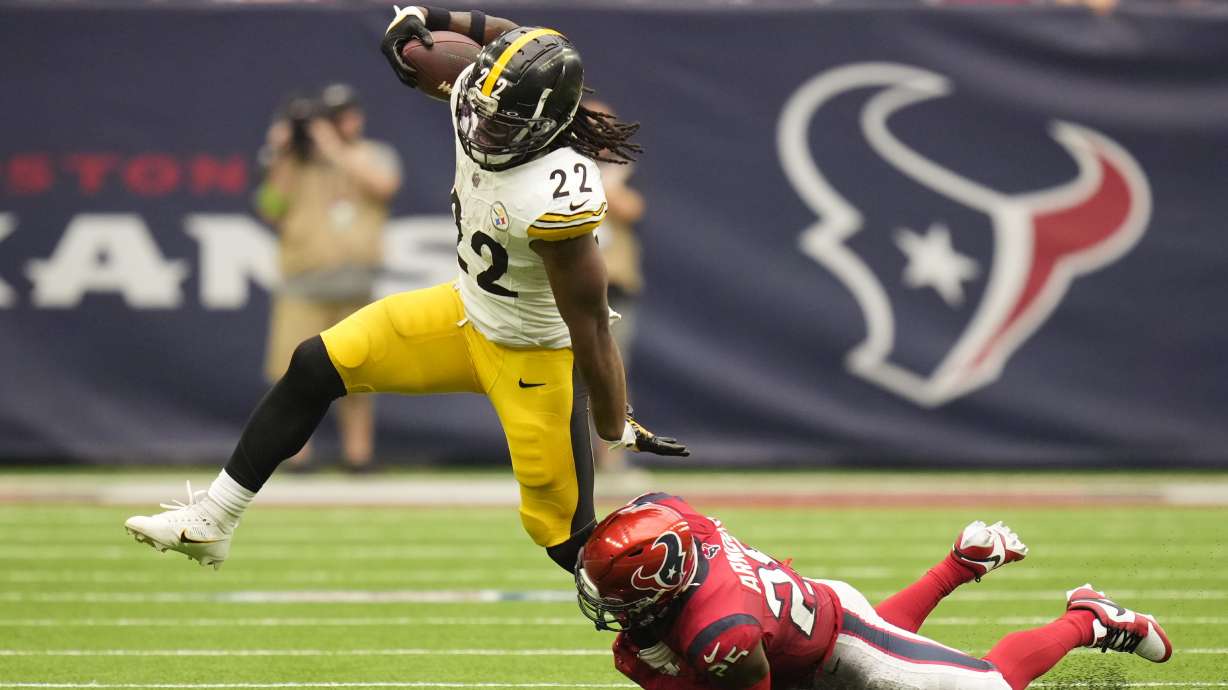 Pittsburgh Steelers running back Najee Harris (22) is grabbed by Houston Texans safety Grayland Arnold (25) during the second half of an NFL football game Sunday, Oct. 1, 2023, in Houston.