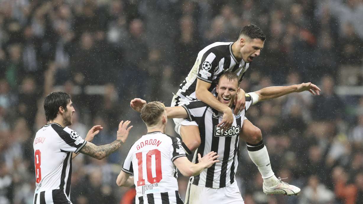 Newcastle's Dan Burn, bottom right, celebrates with teammates after scoring his side's second goalduring the Champions League group F soccer match between Newcastle and Paris Saint Germain at St. James' Park, Wednesday, Oct. 4, 2023, in Newcastle, England.