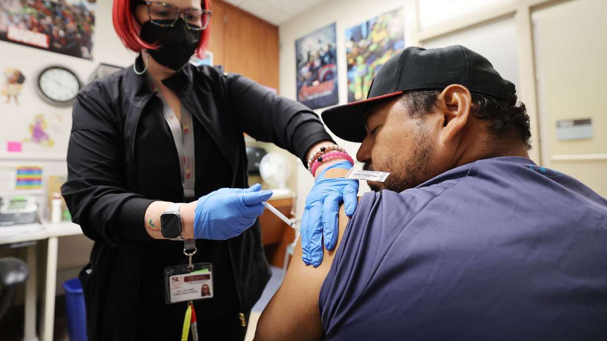 Hugo Varguez receives his COVID-19 vaccine booster from registered nurse Leila Callaway at Salt Lake County Health Center in Salt Lake City on Wednesday. Earlier this week, the Salt Lake County Health Department was so overwhelmed with calls for appointments to get the newly arrived COVID-19 vaccine that people were waiting on hold for up to 45 minutes.