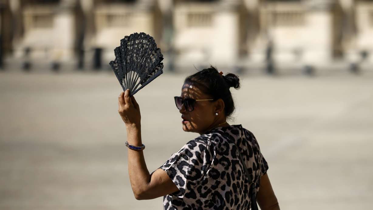 A woman uses a fan in the courtyard of the Louvre museum, Sept. 7, in Paris. After a summer of record-smashing heat, warming somehow got even worse in September as Earth set a new mark for how far above normal temperatures were.