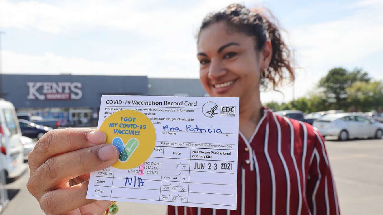 Ana Patricia Jenkins holds her vaccination record card after receiving a COVID-19 vaccination at pop-up clinic in Clearfield on June 23, 2021. The CDC announced it’s no longer distributing the wallet-sized white cards issued during the pandemic.