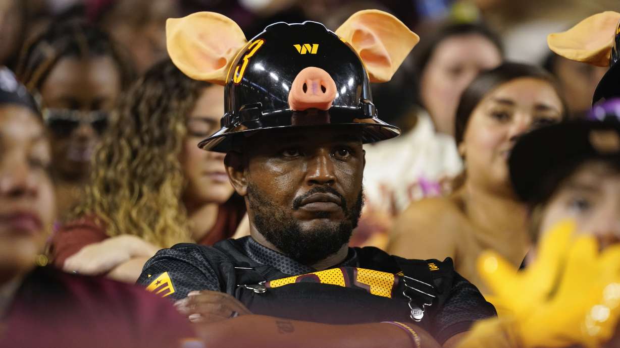 A Washington Commanders fan sitting in the stands during the first half of an NFL football game against the Chicago Bears, Thursday, Oct. 5, 2023, in Landover, Md.