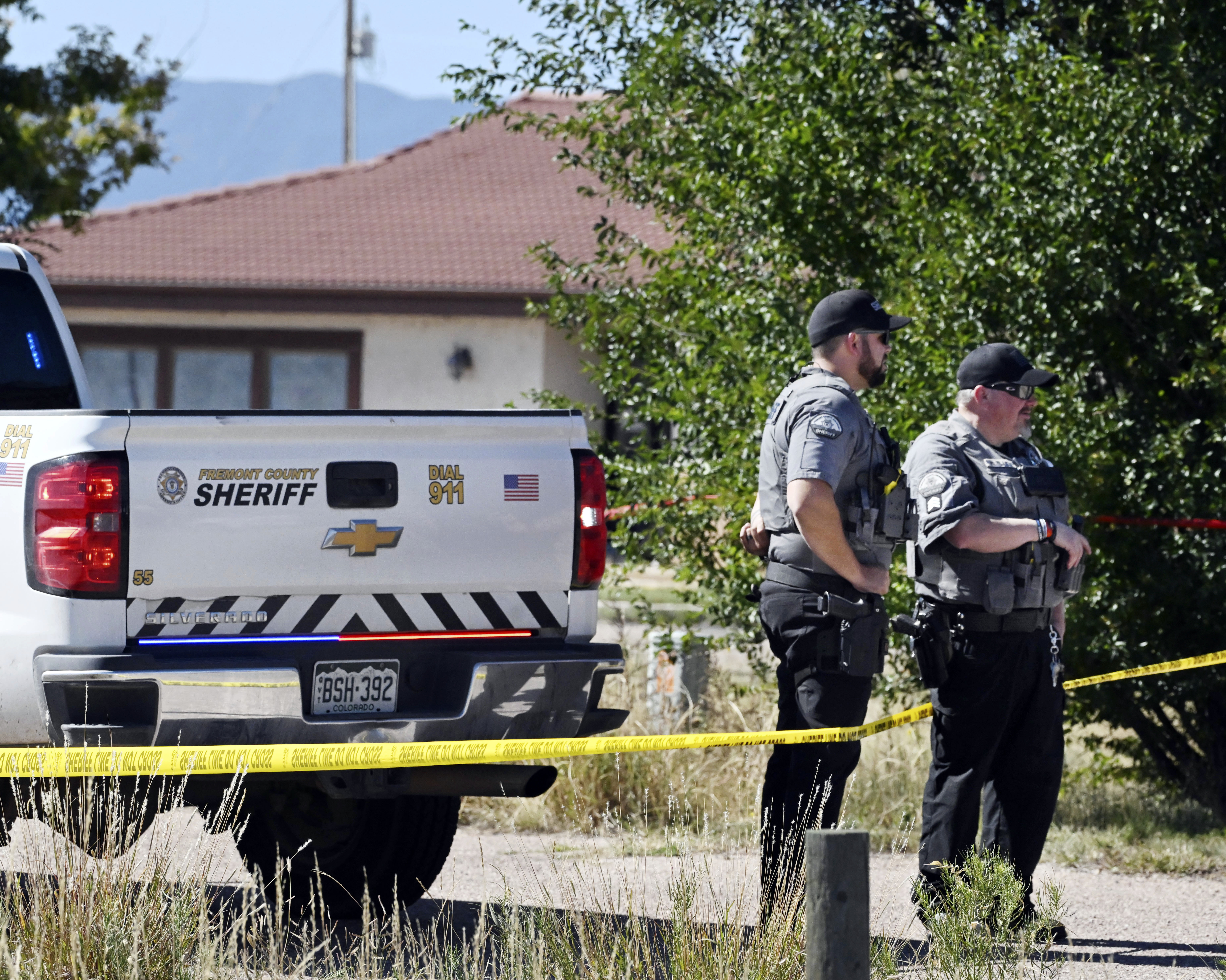 Fremont County deputies guard the road leading to the Return to Nature Funeral Home in Penrose, Colo. Thursday. Authorities said they were investigating the improper storage of human remains at the funeral home that performs “green” burials without embalming chemicals or metal caskets.