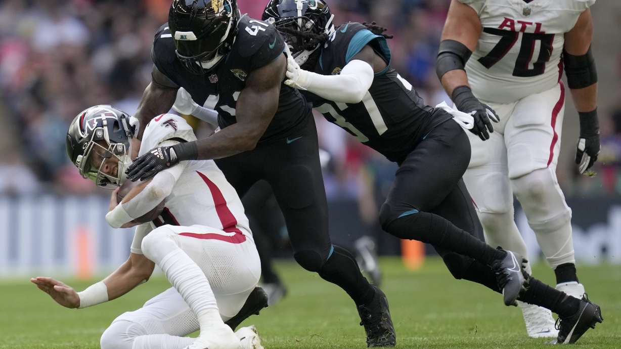 Atlanta Falcons quarterback Desmond Ridder (9), left, is sacked by Jacksonville Jaguars linebacker Josh Allen (41) and Jacksonville Jaguars tight end Evan Engram (17), right, during the first quarter of an NFL football game between the Atlanta Falcons and the Jacksonville Jaguars at Wembley stadium in London, Sunday, Oct. 1, 2023.