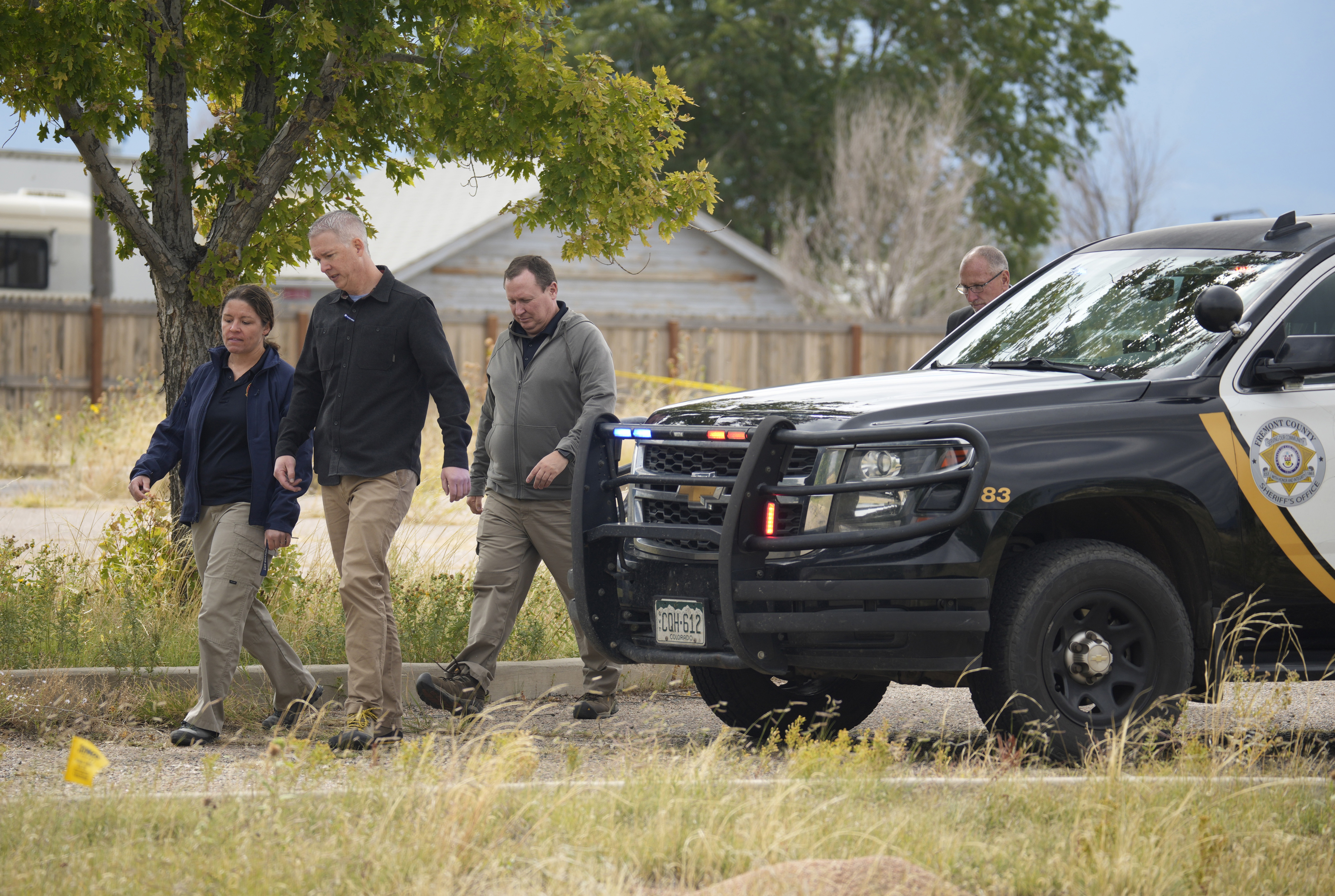 Authorities walk outside a closed funeral home where 115 bodies have been stored, Friday in Penrose, Colo. Authorities are investigating the improper storage of human remains at a southern Colorado funeral home.