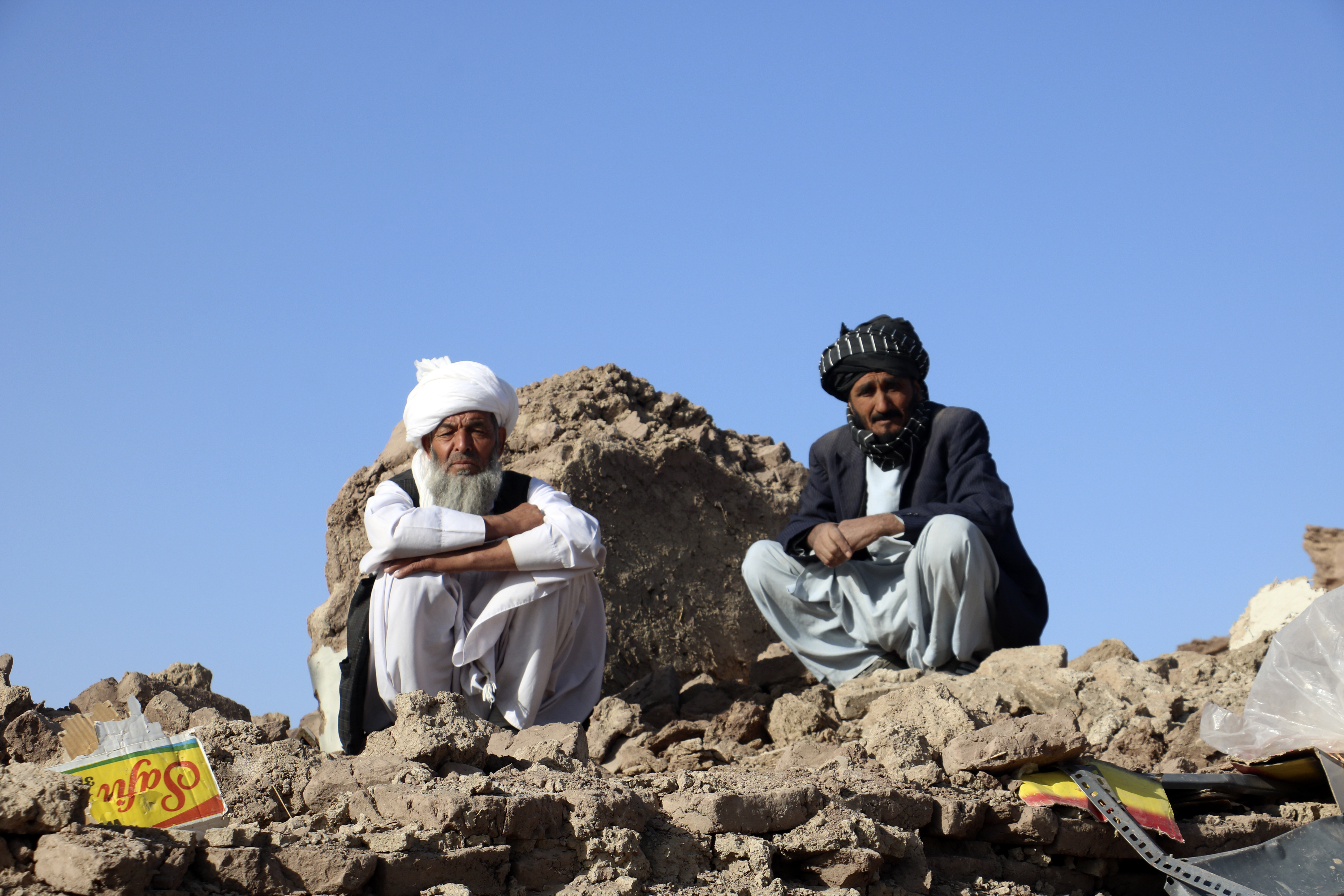 Afghan men sit on the rubble of their destroyed homes after an earthquake in Zenda Jan district in Herat province, of western Afghanistan, Sunday. Powerful earthquakes killed at least 2,000 people in western Afghanistan, a Taliban government spokesman said Sunday. It's one of the deadliest earthquakes to strike the country in two decades.