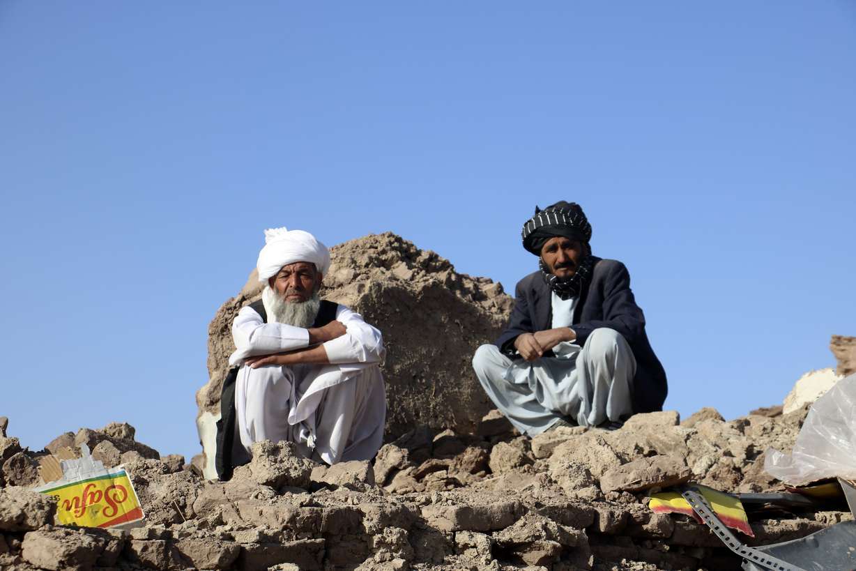 Afghan men sit on the rubble of their destroyed homes after an earthquake in Zenda Jan district in Herat province, of western Afghanistan, Sunday. Powerful earthquakes killed at least 2,000 people in western Afghanistan, a Taliban government spokesman said Sunday. It's one of the deadliest earthquakes to strike the country in two decades.