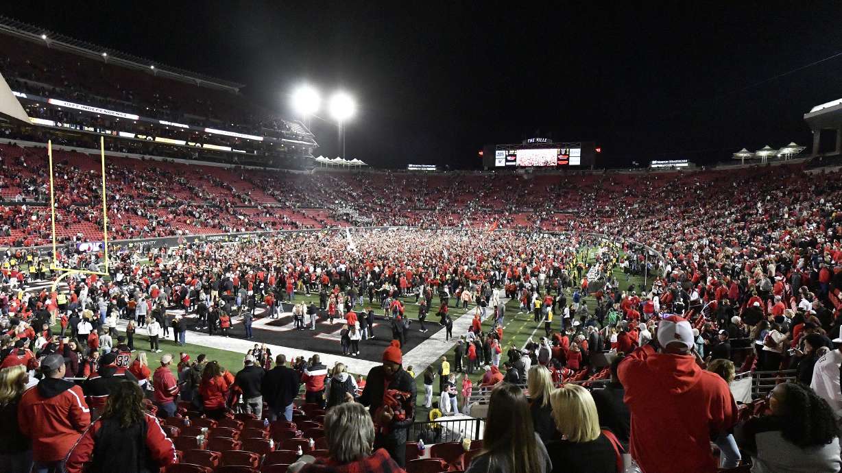 Fans flood the field following Louisville's victory over Notre Dame in an NCAA college football game in Louisville, Ky., Saturday, Oct. 7, 2023.