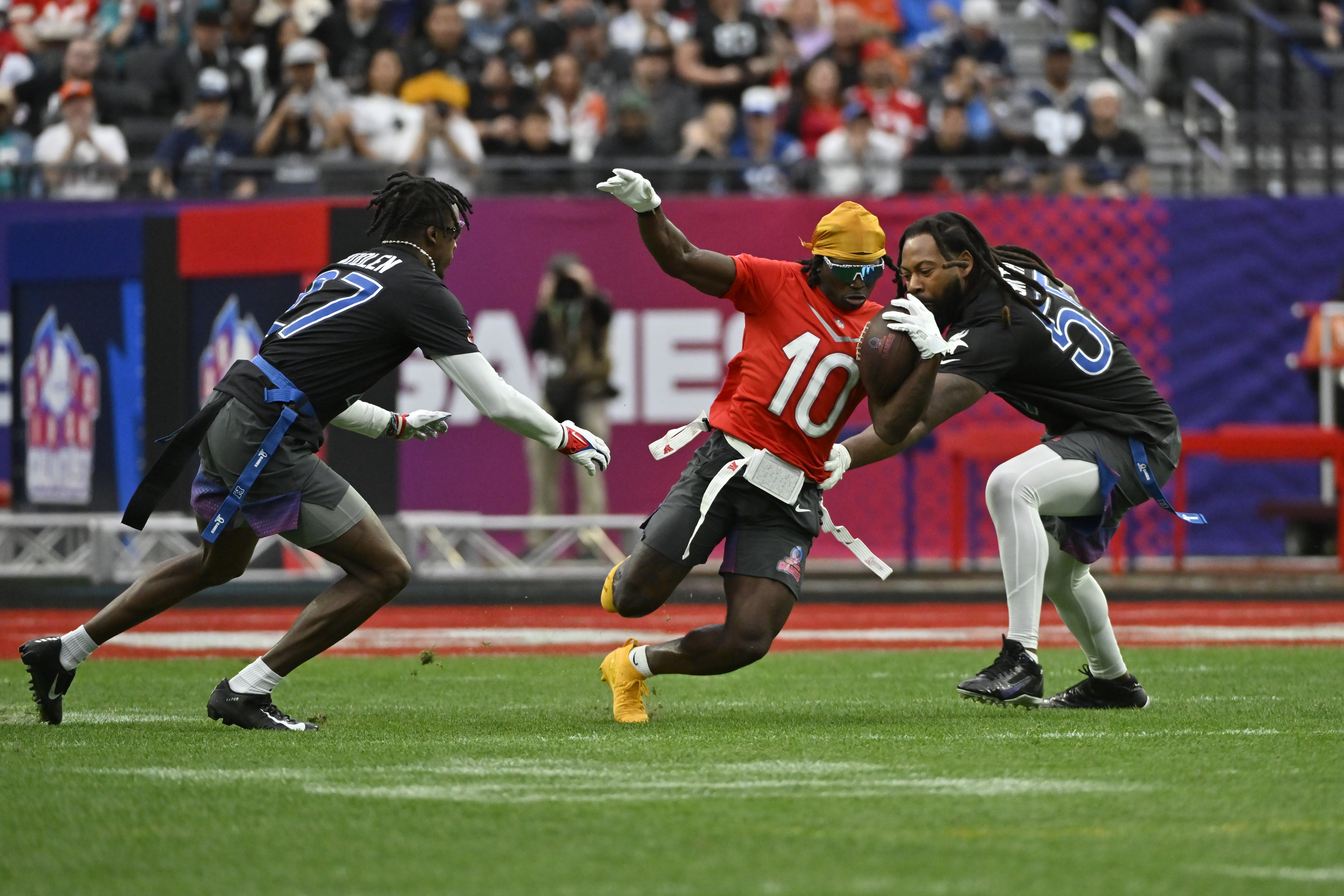 FILE - AFC wide receiver Tyreek Hill (10) of the Miami Dolphins carries the ball against NFC cornerback Tariq Woolen (27) of the Seattle Seahawks and outside linebacker Za'Darius Smith (55) of the Minnesota Vikings during the flag football event at the NFL Pro Bowl, Feb. 5, 2023, in Las Vegas. Flag football took a key step toward becoming an Olympic sport in 2028, a victory for the NFL and organizers in Los Angeles who will bring a distinctly American sport to the Summer Games as they return to the United States for the first time in 32 years.