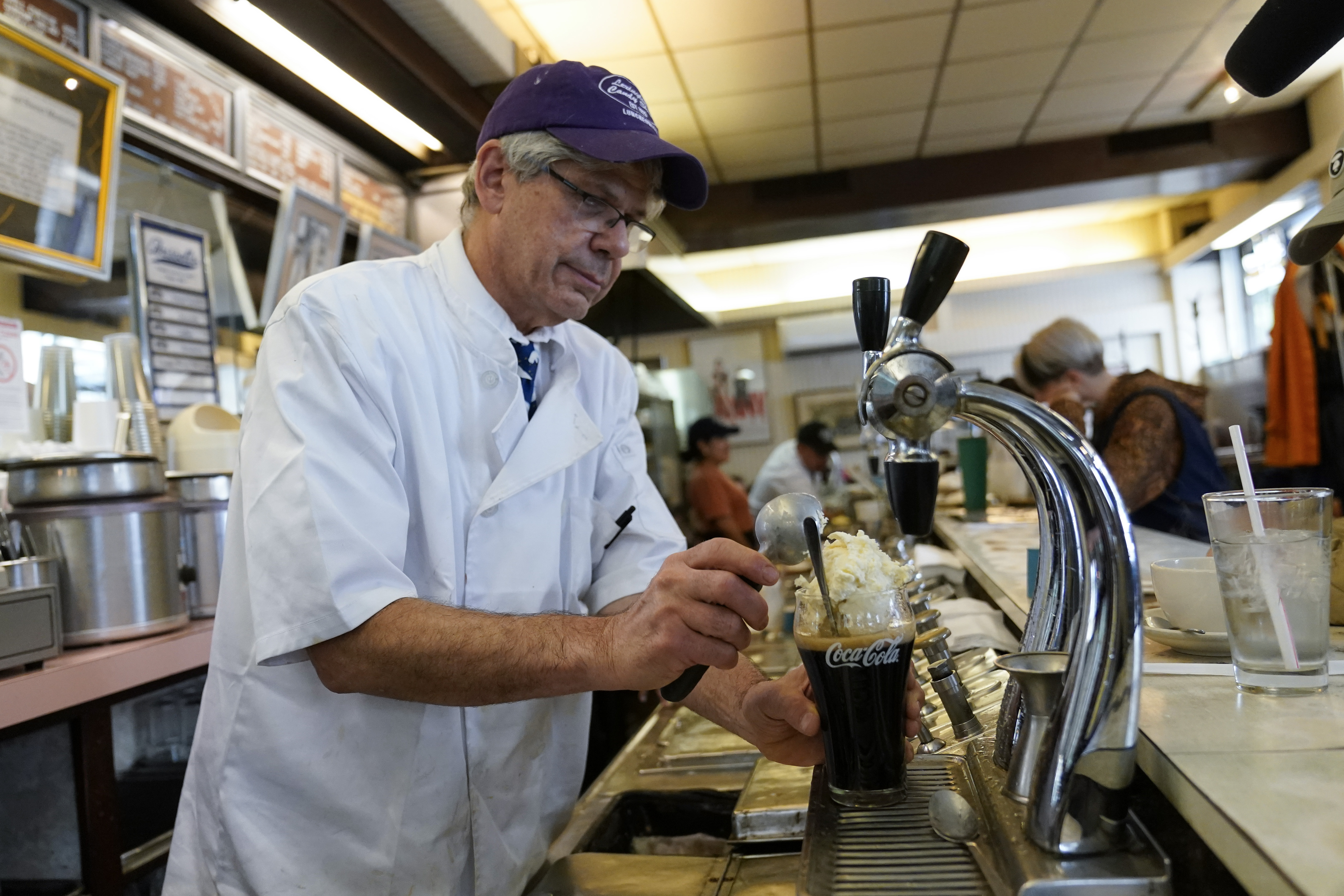 John Philis prepares a Coke float at Lexington Candy Shop, Sept. 28 in New York. The old school business met the new world when Nicolas Heller, a TikToker and Instagrammer with 1.2 million followers, popped in for a traditional Coke float.