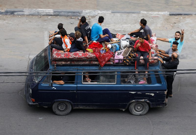 Palestinians flee their homes with their belongings, amid Israeli strikes, in Gaza City Tuesday.