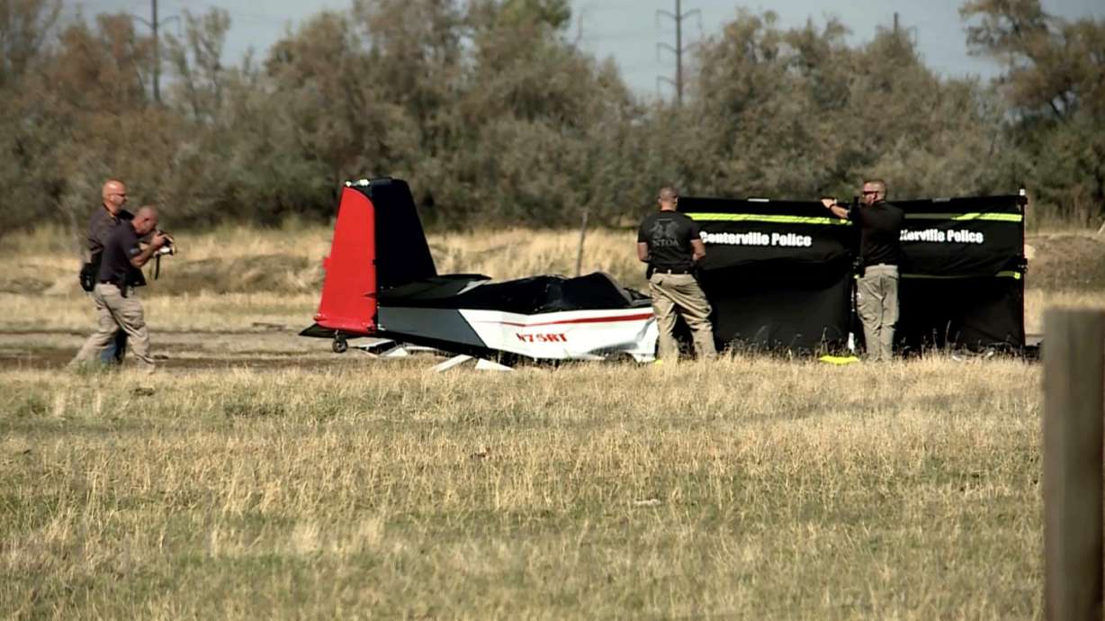 Police investigate the wreckage of a small plane after it crashed in a field at 1500 North just west of the Legacy Parkway in Centerville on Tuesday. Police said the pilot died in the crash.
