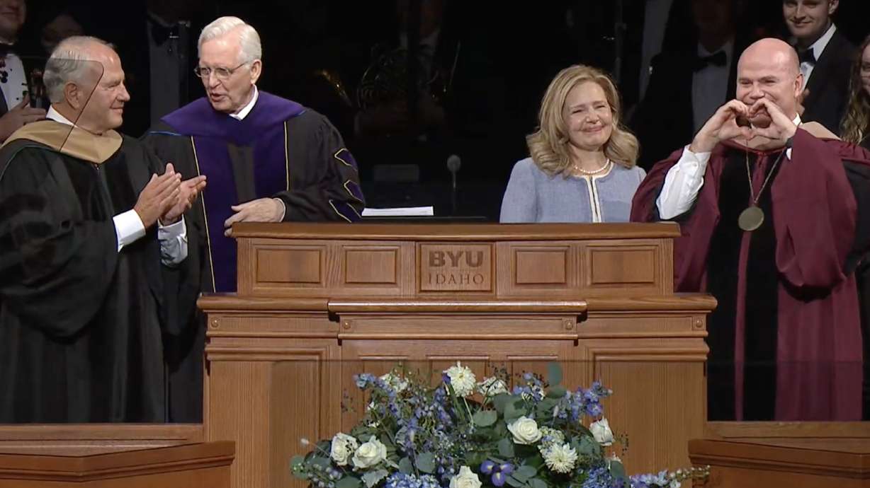 New BYU-Idaho President Alvin F. Meredith makes a heart sign next to his wife, Jennifer Meredith, after he was formally installed by Elders Ronald A. Rasband, left, and D. Todd Christofferson at the BYU-Idaho Center in Rexburg on Tuesday.