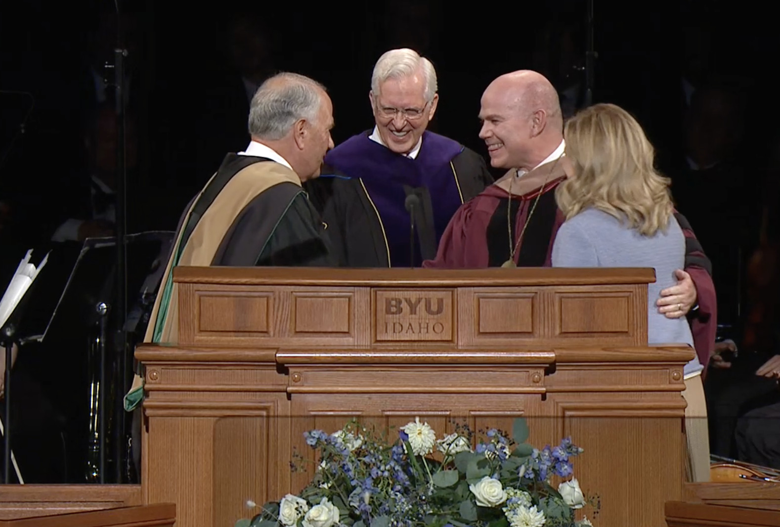 Elders Ronald A. Rasband, left, and D. Todd Christofferson congratulate new BYU-Idaho President Alvin F. Meredith and his wife, Jennifer, at his inauguration at the BYU-Idaho Center in Rexburg, Idaho, on Tuesday.
