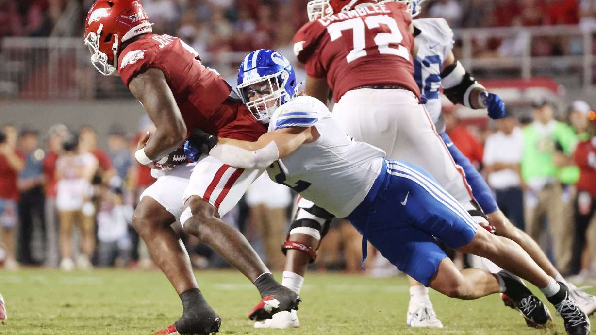 Brigham Young linebacker Ben Bywater (2) tries to sack Arkansas Razorbacks quarterback KJ Jefferson (1) at Razorback Stadium in Fayetteville on Saturday, Sept. 16, 2023. BYU won 38-31.