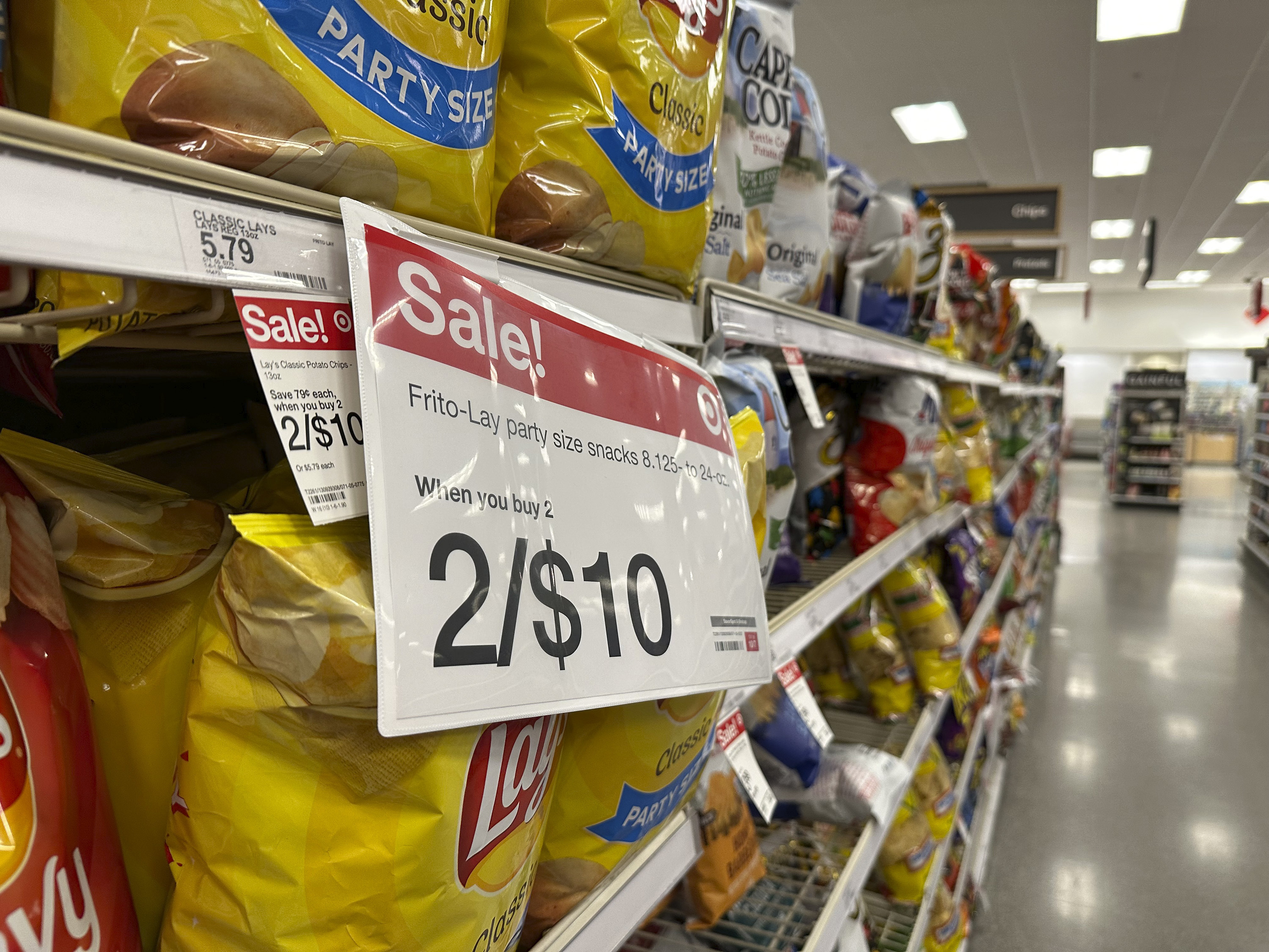 A sale sign hangs below a shelf of potato chips in a Target store Oct. 4, in Sheridan, Colo. Measures of U.S. inflation in September showed that the pace of price increases is still grinding lower, the government reported Thursday.