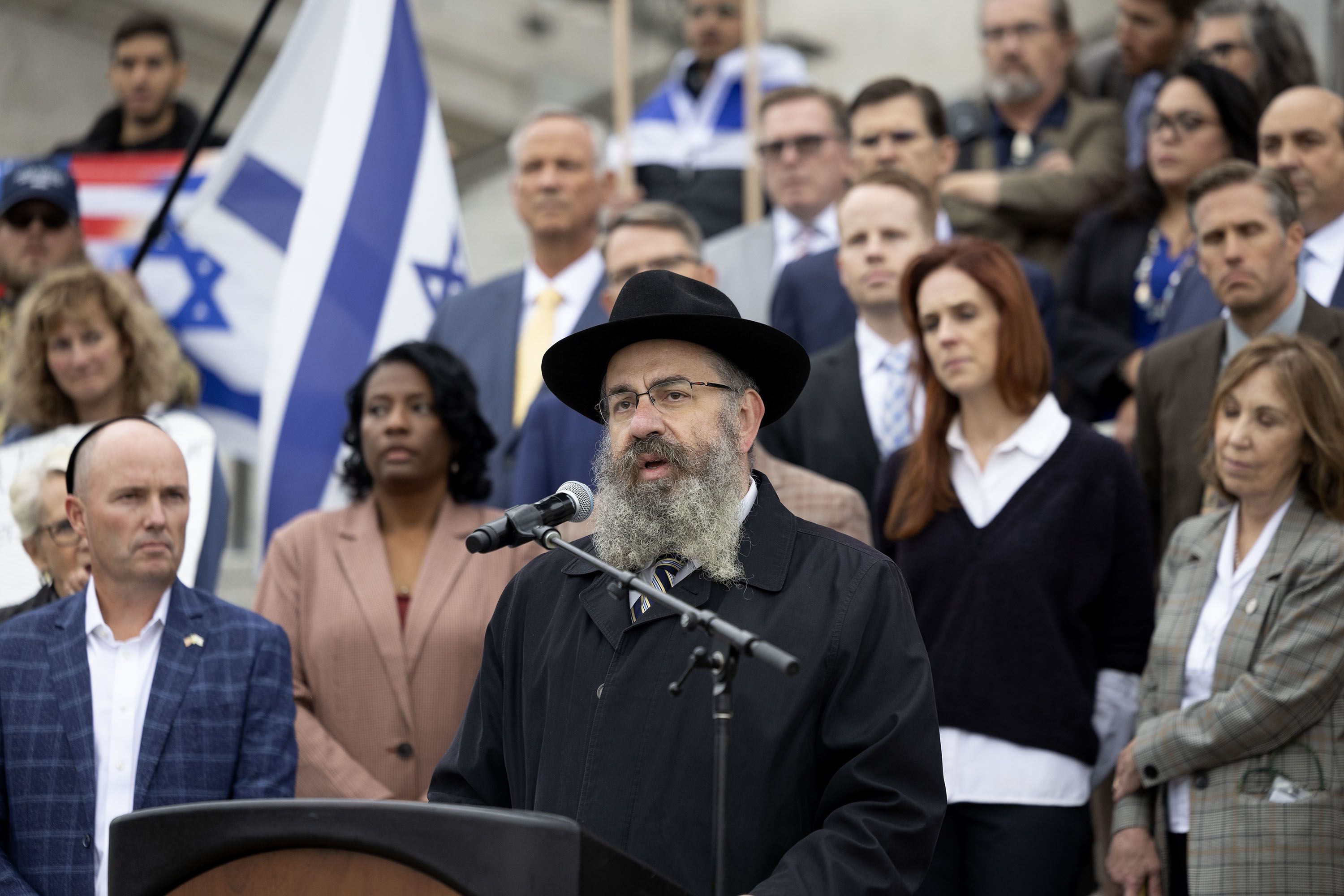 Utah legislators and the governor stand with Rabbi Benny Zippel, executive director of Chabad of Utah, as he speaks at the Stand with Israel rally at the Capitol in Salt Lake City on Wednesday.