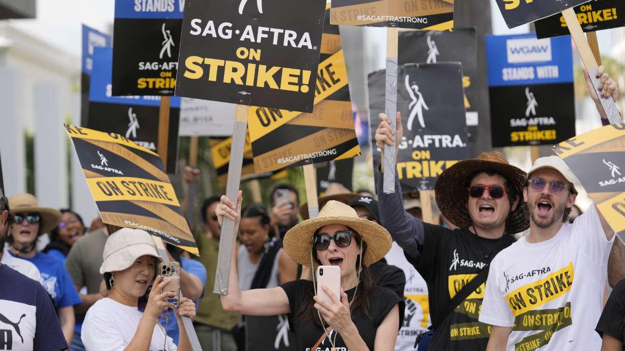 Picketers carry signs on the picket line outside Netflix on Sept. 27 in Los Angeles. Strike talks have broken off between Hollywood actors and studios.