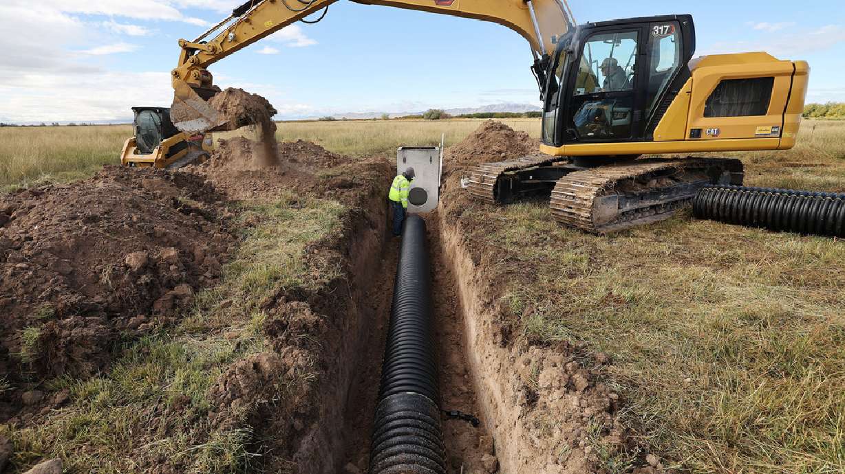 Austin Thomas and Travis Call install some irrigation pipeline to replace ditches on the New Harvey pastures in Davis County Oct. 11, 2023. A lawmaker is requesting money to help Utah track whether water conservation efforts are helping.
