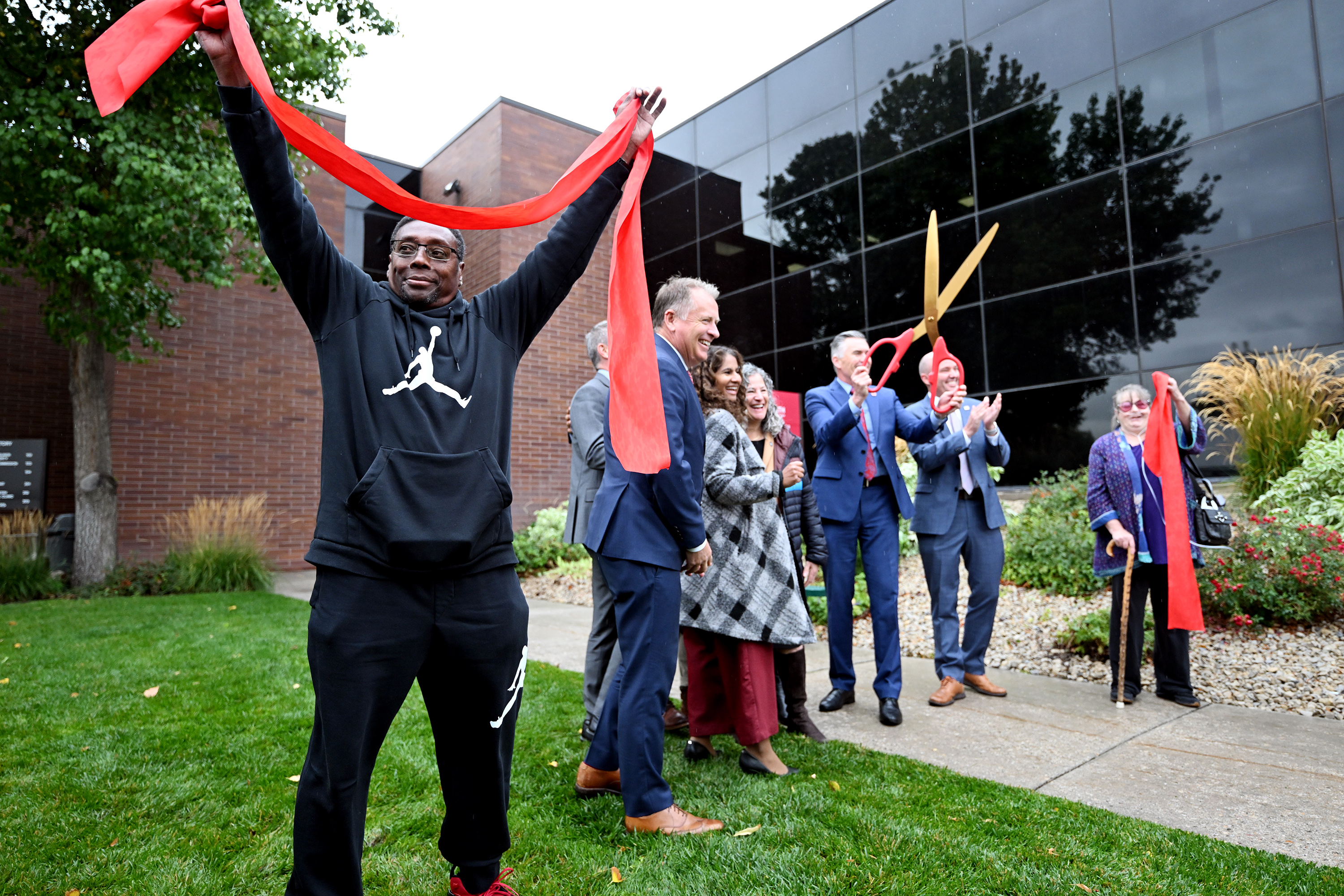 Adolphus Nickelberry holds a portion of the cut ribbon as he and others attend a celebration at the University of Utah Health’s new Rose Park Population Health Center on Thursday.