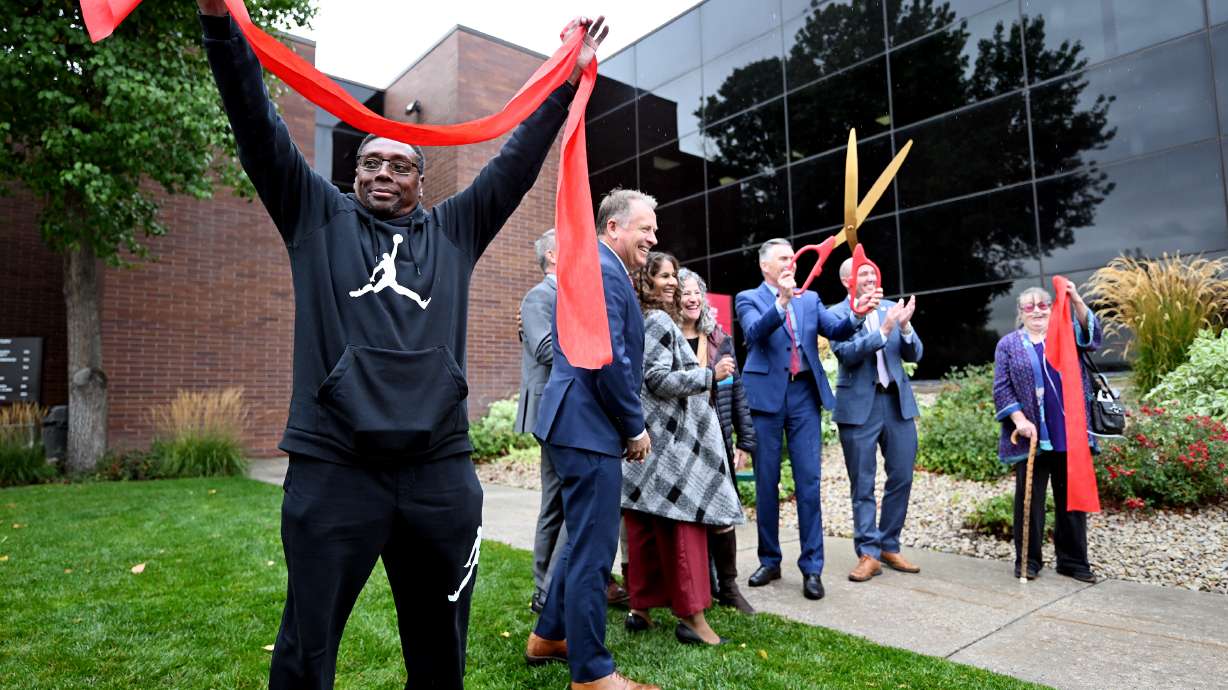 Adolphus Nickelberry holds a portion of the cut ribbon as he and others attend a celebration at the University of Utah Health’s new Rose Park Population Health Center on Thursday.