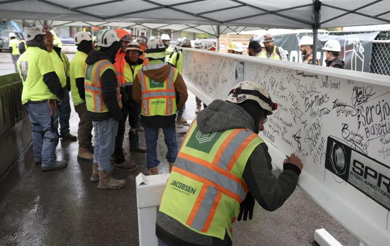 Construction workers sign the final steel beam before its ceremonial placement atop the 40th floor of Astra Tower in Salt Lake City on Thursday. When finished, the 40-story Astra Tower in Salt Lake City's downtown will be Utah’s tallest high-rise at 450 feet. - Laura Seitz, Deseret News