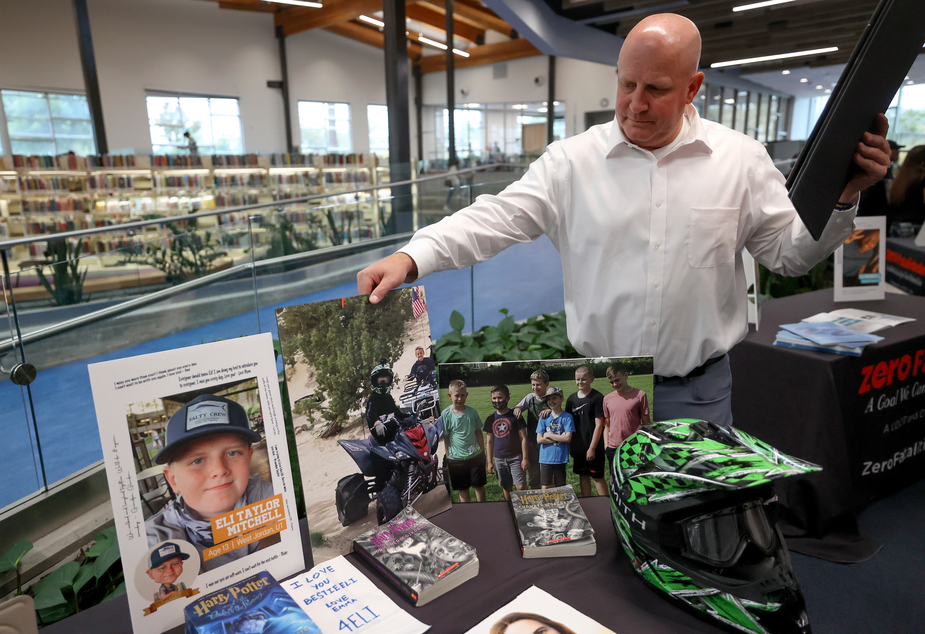 Jeremy Mitchell packs up photos of his son Eli Mitchell, who was hit and killed by a drunk driver while riding his bike April 26, 2022. The family attended a press event hosted by Utah Department of Health and Human Services, Utah Department of Transportation and Utah Department of Public Safety ahead of National Teen Driver Safety Week at the Kearns Library in Kearns on Thursday.