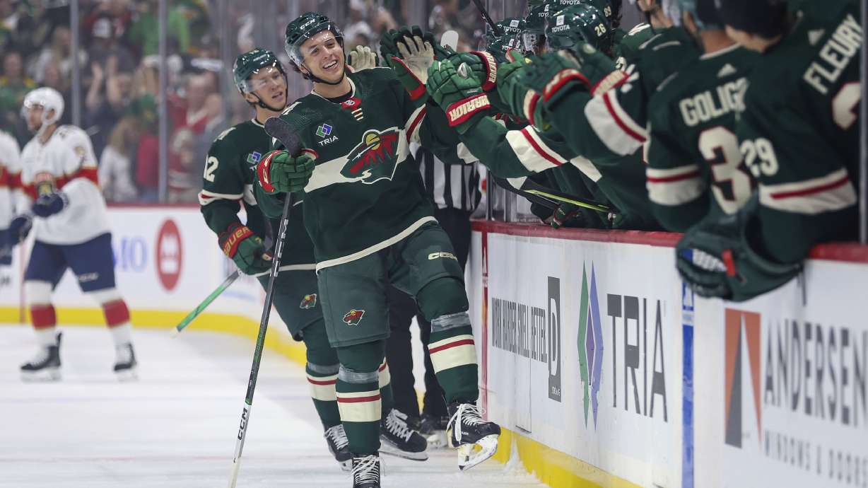 Minnesota Wild defenseman Brock Faber, front left, is congratulated for his goal against the Florida Panthers during the first period of an NHL hockey game Thursday, Oct. 12, 2023, in St. Paul, Minn.