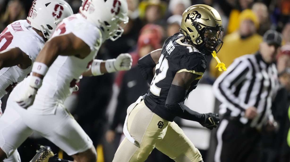 Colorado wide receiver Travis Hunter, right, gets away Stanford safety Alaka'i Gilman, front left, and cornerback Jaden Slocum on the way to scoring a touchdown during the first half of an NCAA college football game Friday, Oct. 13, 2023, in Boulder, Colo.