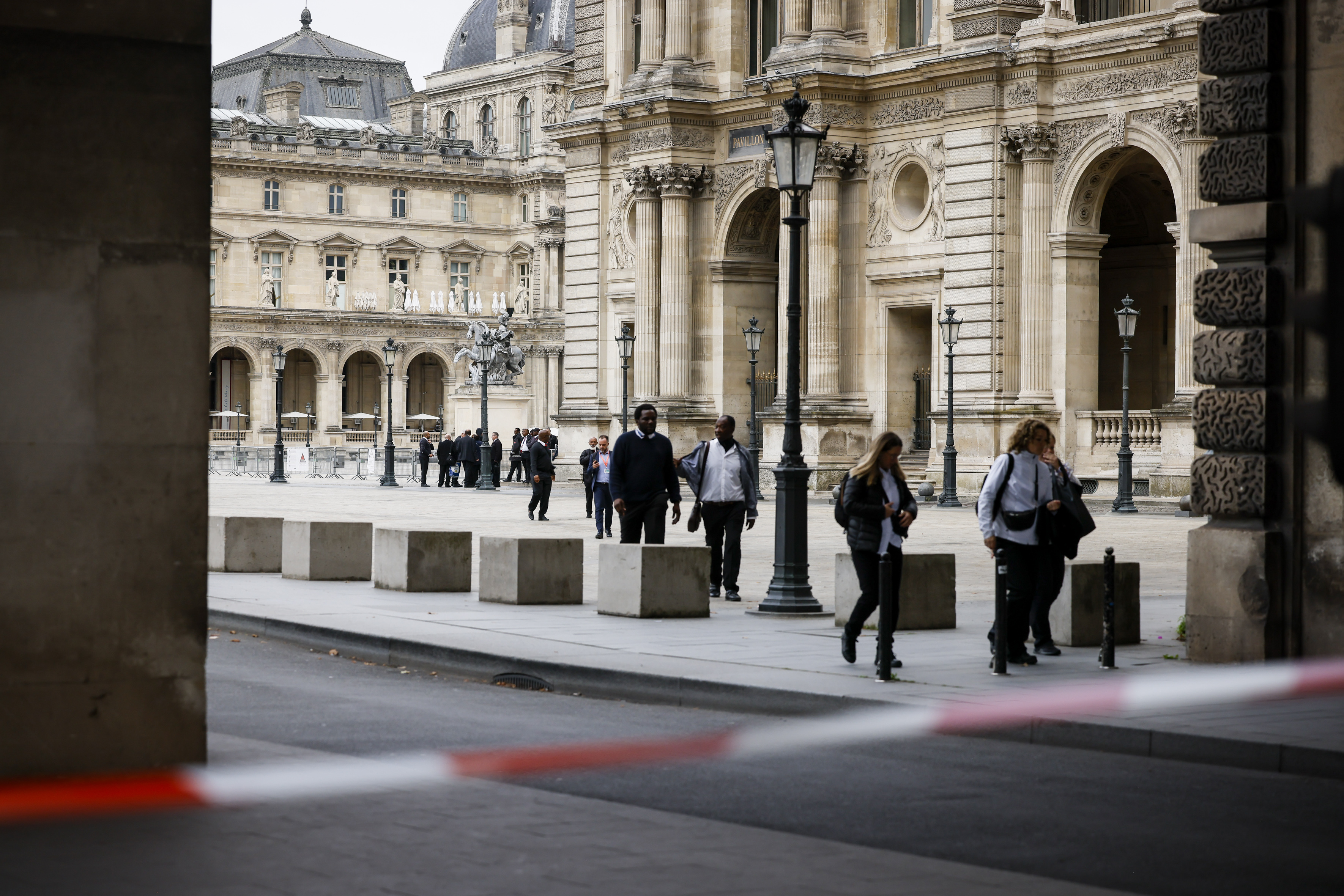 Staff leave the Louvre Museum as people are evacuated after it received a written threat, in Paris, Saturday. The Louvre Museum says it is closing for the day and evacuating all visitors and staff after a threat. 