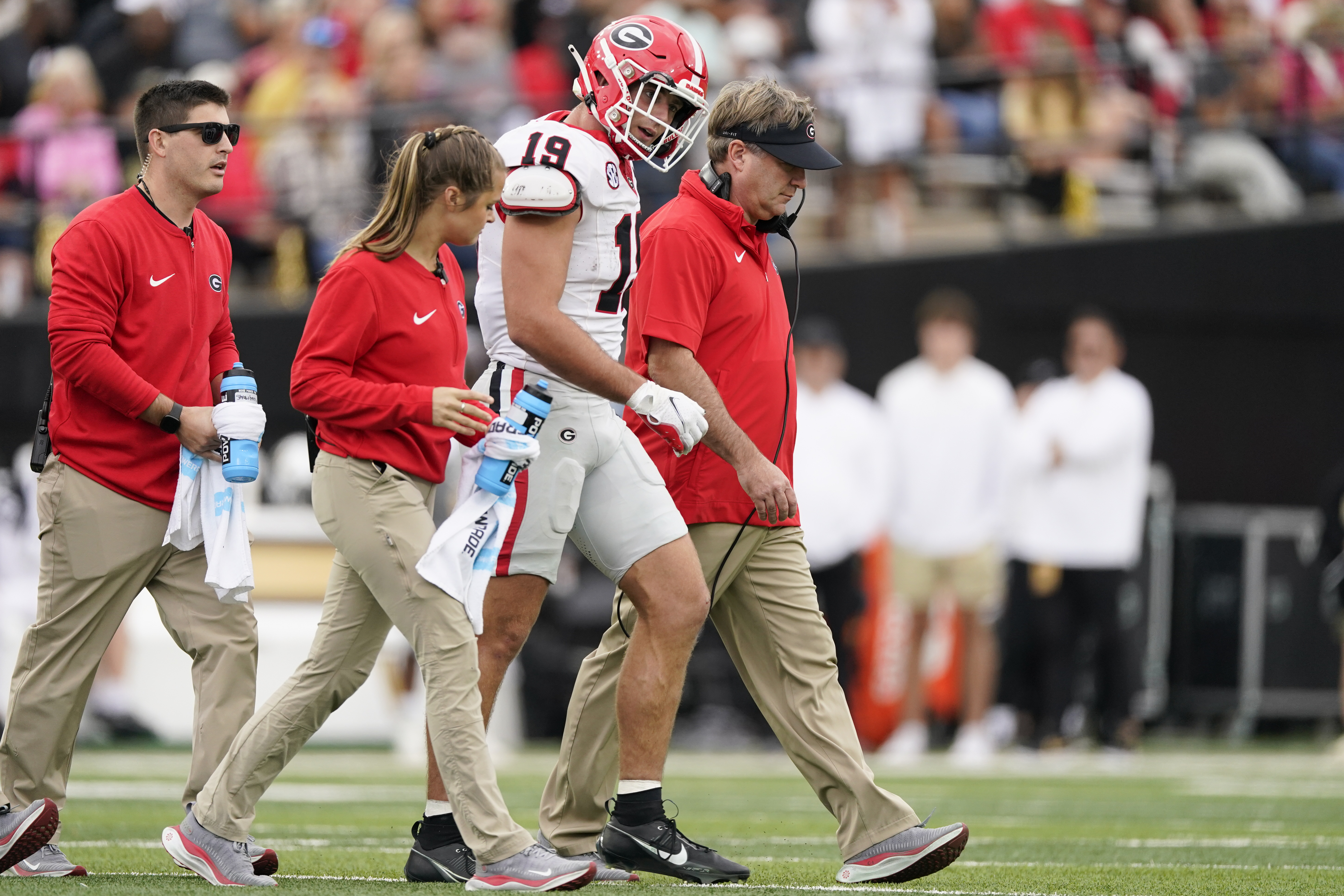 Georgia tight end Brock Bowers (19) walks of the field with head coach Kirby Smart, right, after being injured in the first half of an NCAA college football game against Vanderbilt, Saturday, Oct. 14, 2023, in Nashville, Tenn. 