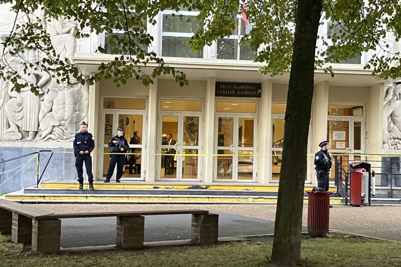 Police officers stand guard outside the high school where a man stabbed a teacher, Saturday in Arras, northern France.