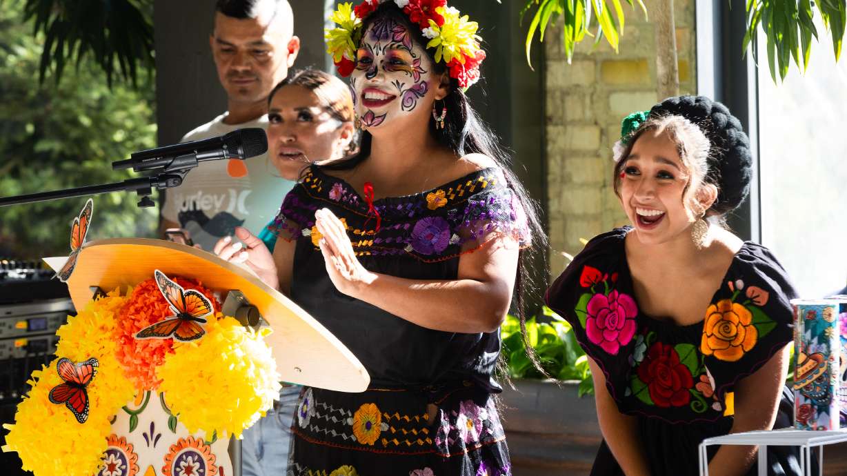 Left to right, Gabby Chavez and Jelcy Cruz clap during a performance at the annual Dia de los Muertos celebration hosted by Una Mano Amiga at Trolley Square in Salt Lake City on Saturday.