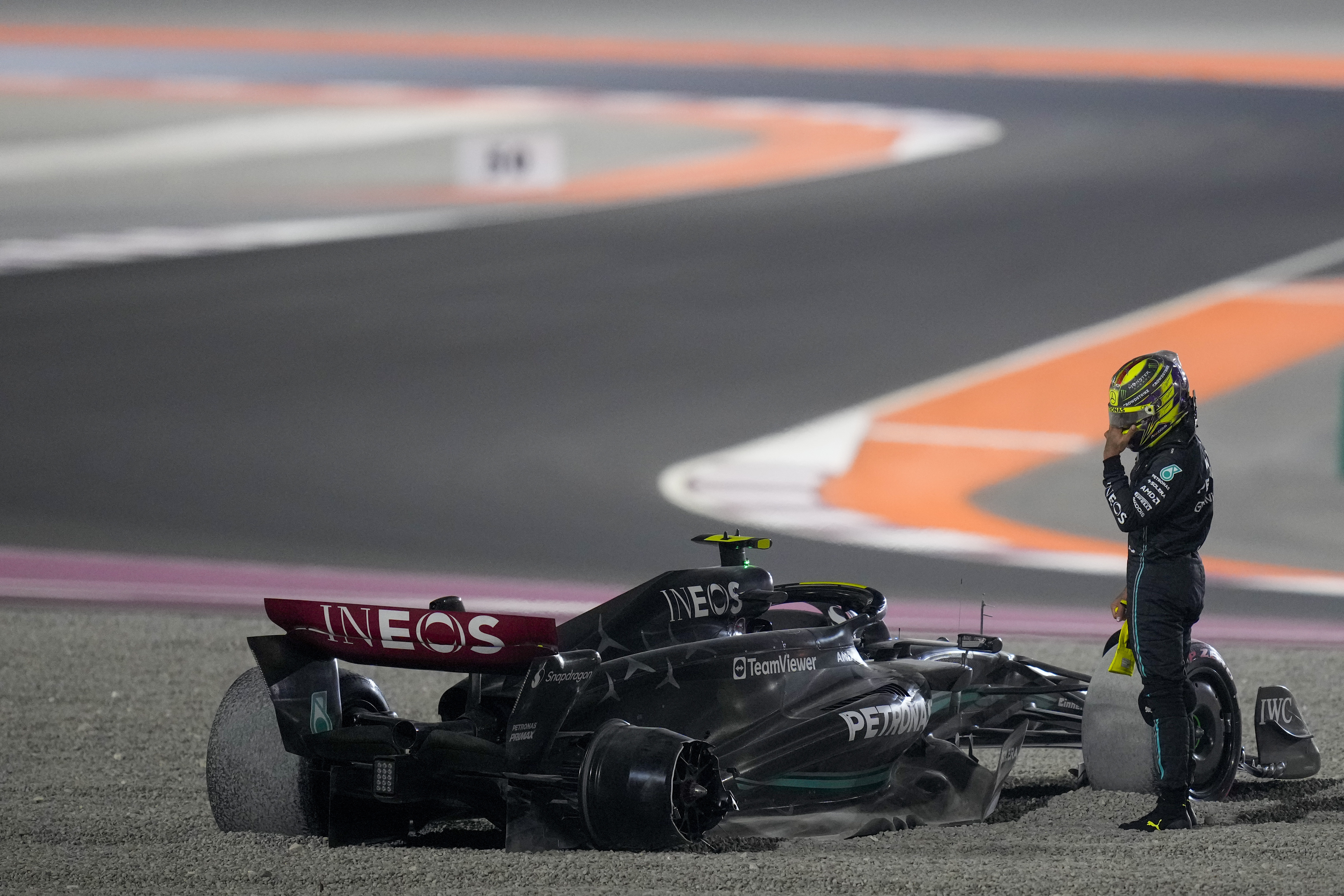 Mercedes driver Lewis Hamilton of Britain stands next to his car after a crash at the start of the Qatar Formula One Grand Prix auto race at the Lusail International Circuit, in Lusail, Qatar, Sunday, Oct. 8, 2023. 