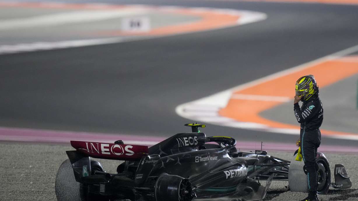 Mercedes driver Lewis Hamilton of Britain stands next to his car after a crash at the start of the Qatar Formula One Grand Prix auto race at the Lusail International Circuit, in Lusail, Qatar, Sunday, Oct. 8, 2023.
