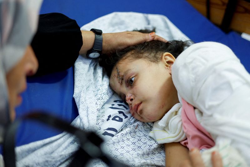 Palestinian girl Fulla Al-Laham, 4, who was wounded in an Israeli strike that killed 14 family members, including her parents and all her siblings, lies on a bed as her grandmother sits next to her, at a hospital in Khan Younis in the southern Gaza Strip, Saturday.