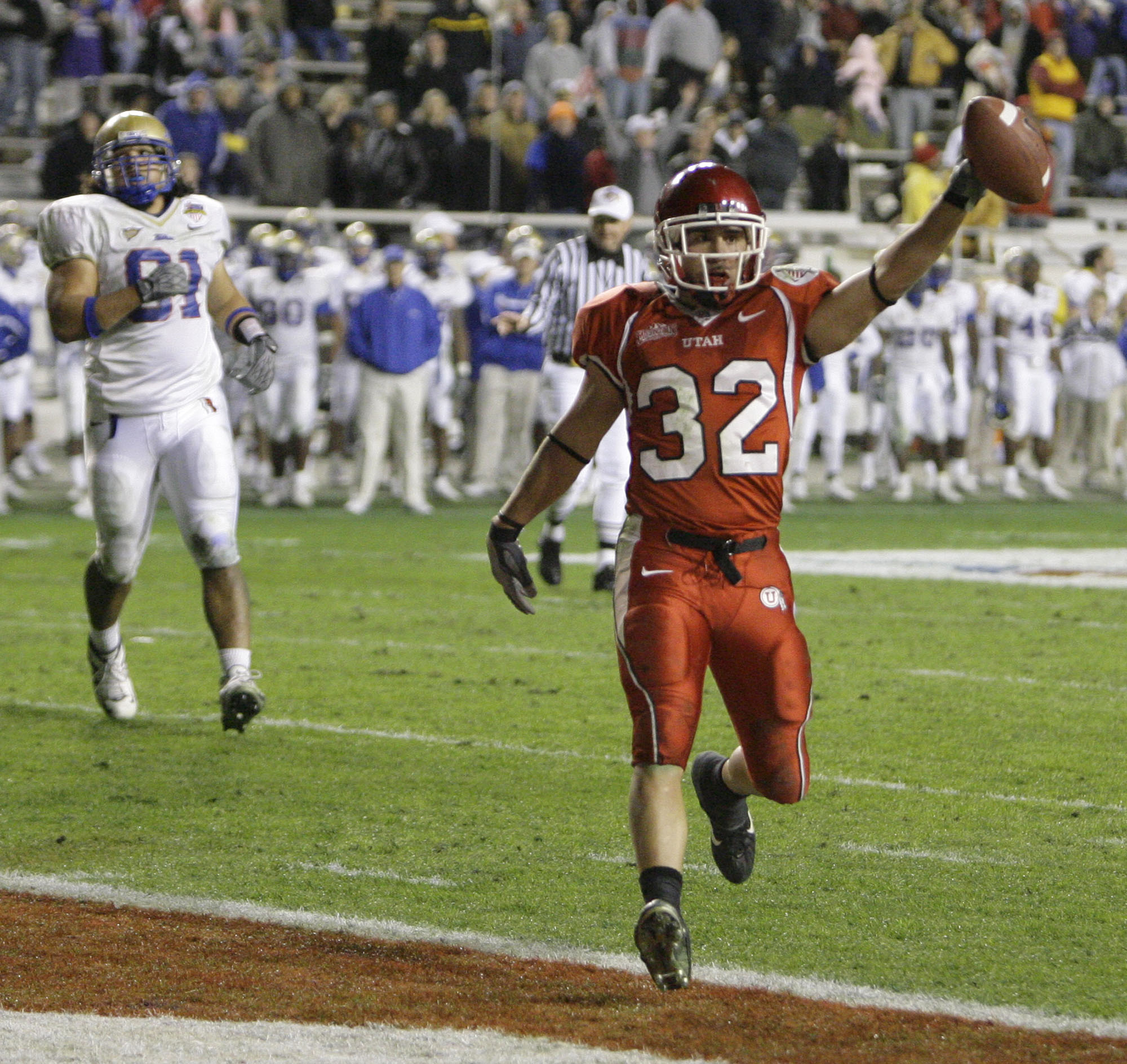 Utah quarterback Eric Weddle (32) scores a touchdown past Tulsa defensive end Robert Latu (91) in the second half of the Armed Forces Bowl football game Saturday, Dec. 23, 2006, in Fort Worth, Texas. Utah won 25-13.