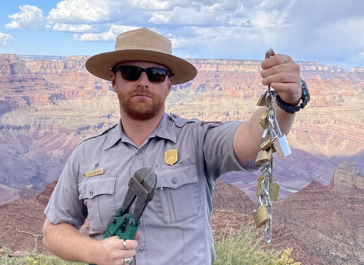 A Grand Canyon National Park ranger holds up padlocks that were removed from the park. Park officials are urging visitors to not leave "love locks" in the park after a recent uptick in the practice.