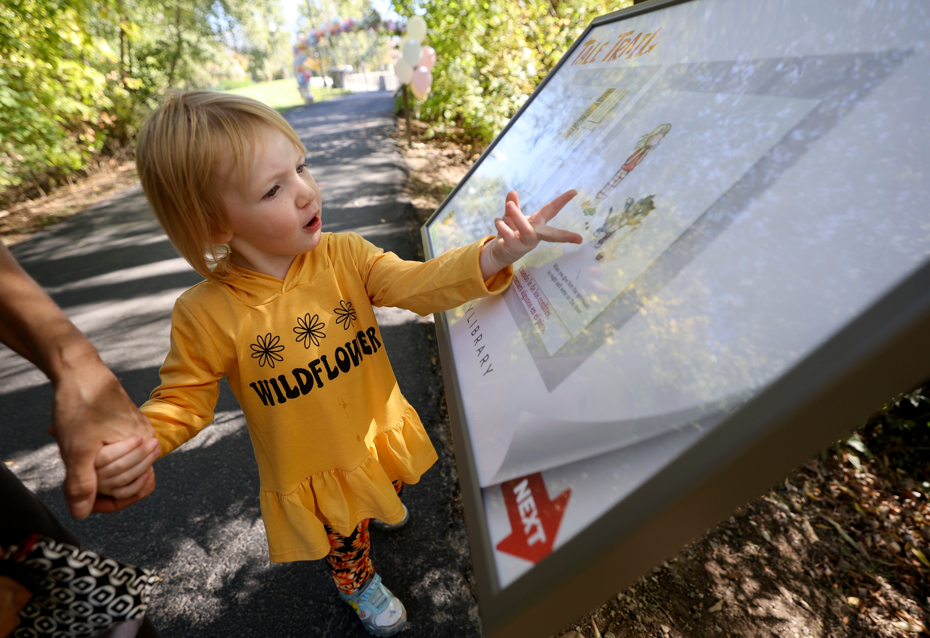 Bentley Barger checks out one of the pages of the featured book, "If You Give a Cat a Cupcake," on the Tale Trail in Murray on Monday. The trail is designed to combine reading and nature.