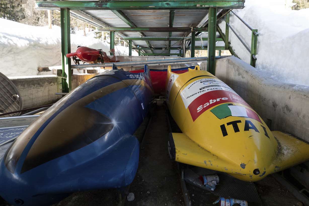 Bobsleds are parked next to the track in Cortina d’Ampezzo, Italy, on Feb. 17, 2021. A big-ticket project for the 2026 Milan-Cortina Olympics has been dropped because the Italian government no longer wants to help fund it, organizing committee officials said Monday.