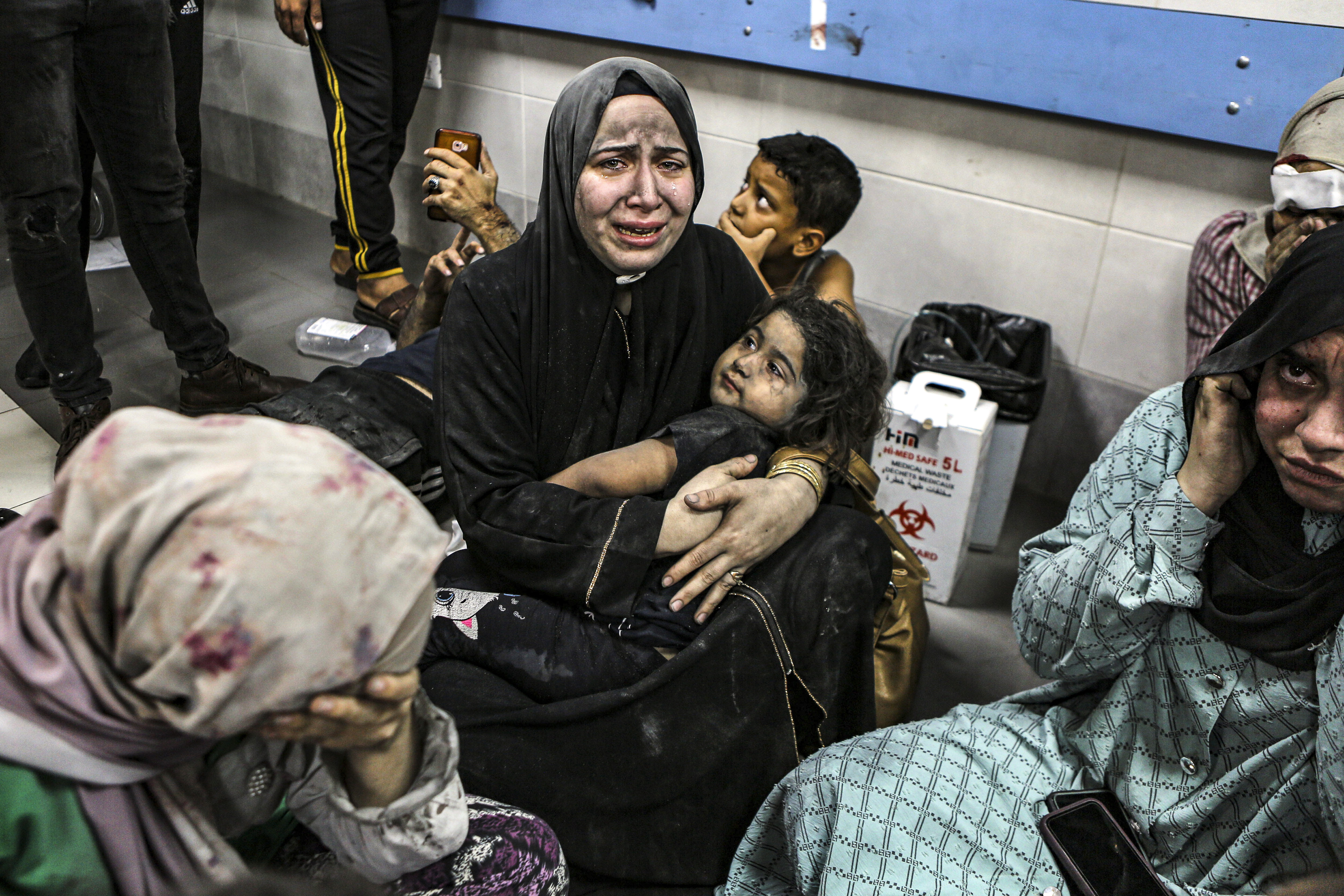 Wounded Palestinians sit in al-Shifa hospital in Gaza City, central Gaza Strip, after arriving from al-Ahli hospital following an explosion there, Tuesday, Oct. 17, 2023. The Hamas-run Health Ministry says an Israeli airstrike caused the explosion that killed hundreds at al-Ahli, but the Israeli military says it was a misfired Palestinian rocket.