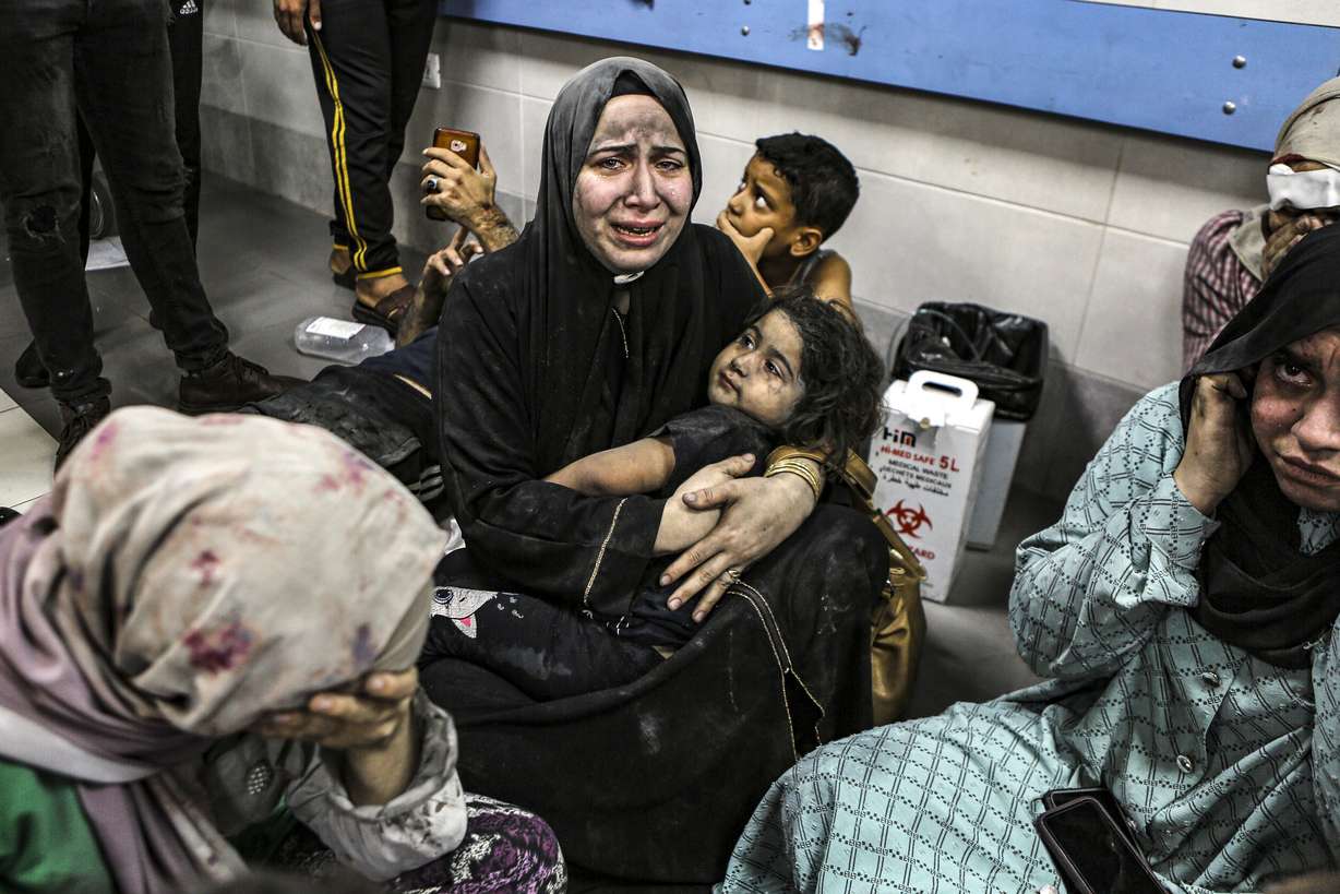 Wounded Palestinians sit in al-Shifa hospital in Gaza City, central Gaza Strip, after arriving from al-Ahli hospital following an explosion there, Tuesday, Oct. 17, 2023. The Hamas-run Health Ministry says an Israeli airstrike caused the explosion that killed hundreds at al-Ahli, but the Israeli military says it was a misfired Palestinian rocket.
