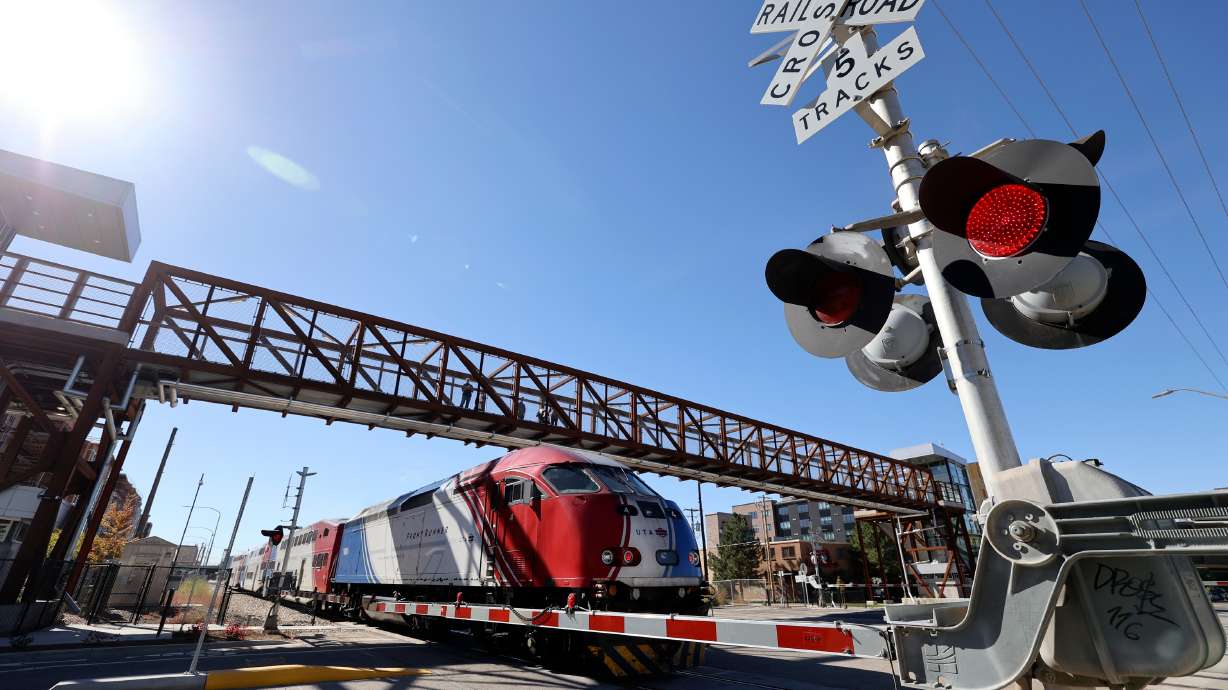A FrontRunner train passes under a new pedestrian bridge at 300 North and 490 West, that crosses two Utah Transit Authority and three Union Pacific rail lines, in Salt Lake City on Wednesday.