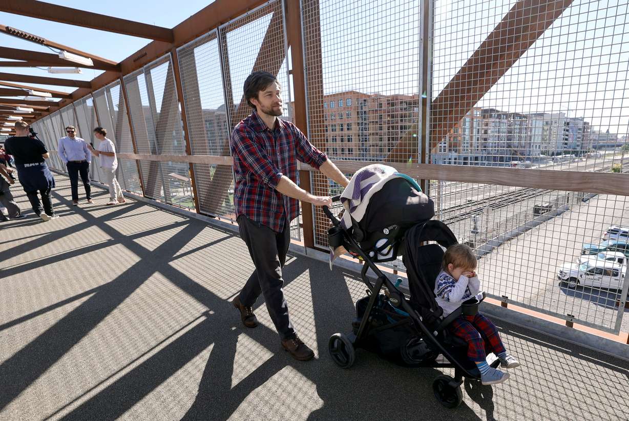 Davey Davis pushes Elliot Davis across a new pedestrian bridge at 300 North and 490 West, that crosses two Utah Transit Authority and three Union Pacific rail lines, in Salt Lake City on Wednesday. The crossing is on a route heavily used by West High School students walking to and from school.