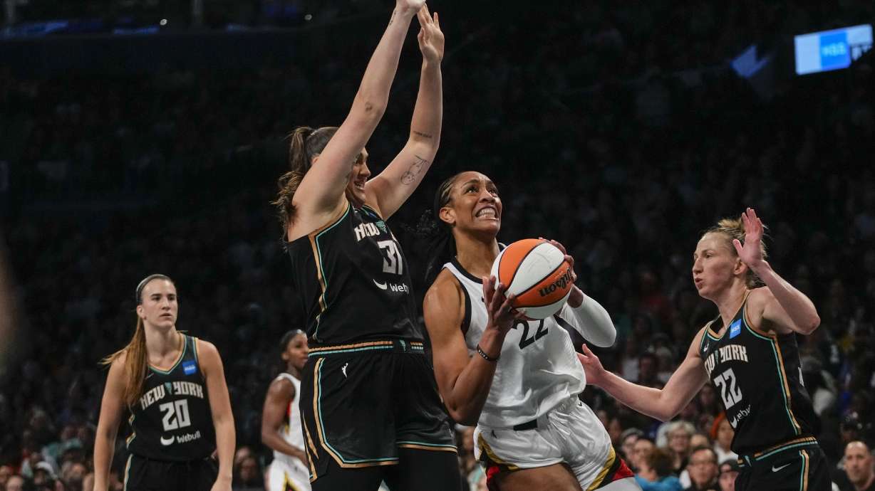 Las Vegas Aces' A'ja Wilson (22) drives to the basket as New York Liberty's Stefanie Dolson (31) and Courtney Vandersloot (22) defends during the first half in Game 4 of a WNBA basketball final playoff series Wednesday, Oct. 18, 2023, in New York.