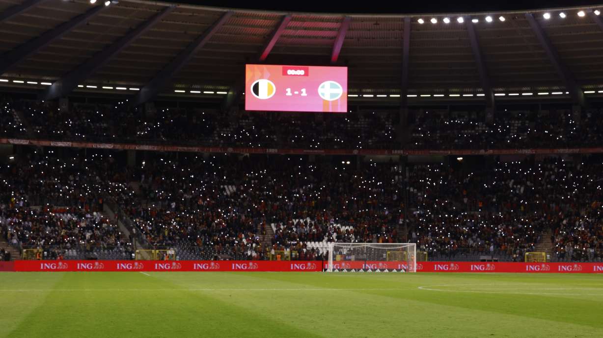 Supporters lit their mobile phones lights after suspension of the Euro 2024 group F qualifying soccer match between Belgium and Sweden at the King Baudouin Stadium in Brussels, Monday, Oct. 16, 2023. Two Swedes were killed in a shooting late Monday in central Brussels, police said, prompting Belgium's prime minister and senior Cabinet minister to hunker down at their crisis center for an emergency meeting.