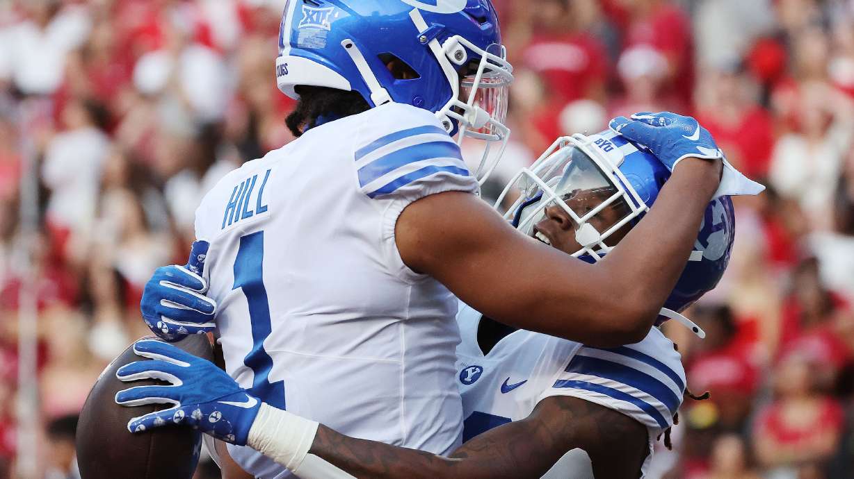 Brigham Young running back Deion Smith (20) celebrates a touchdown with Brigham Young wide receiver Keanu Hill (1) against the Arkansas Razorbacks at Razorback Stadium in Fayetteville on Saturday, Sept. 16, 2023.