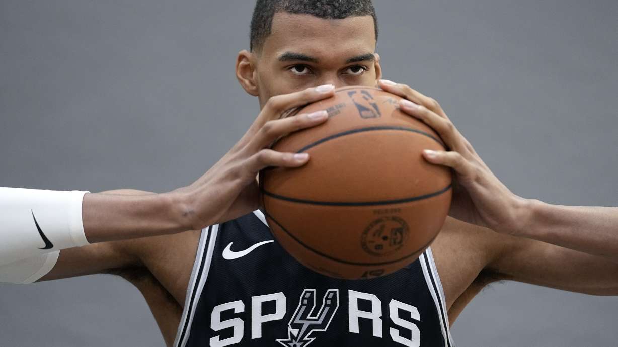 San Antonio Spurs center Victor Wembanyama, the NBA's first round draft pick, poses for photos during an NBA basketball media day in San Antonio, Monday, Oct. 2, 2023.