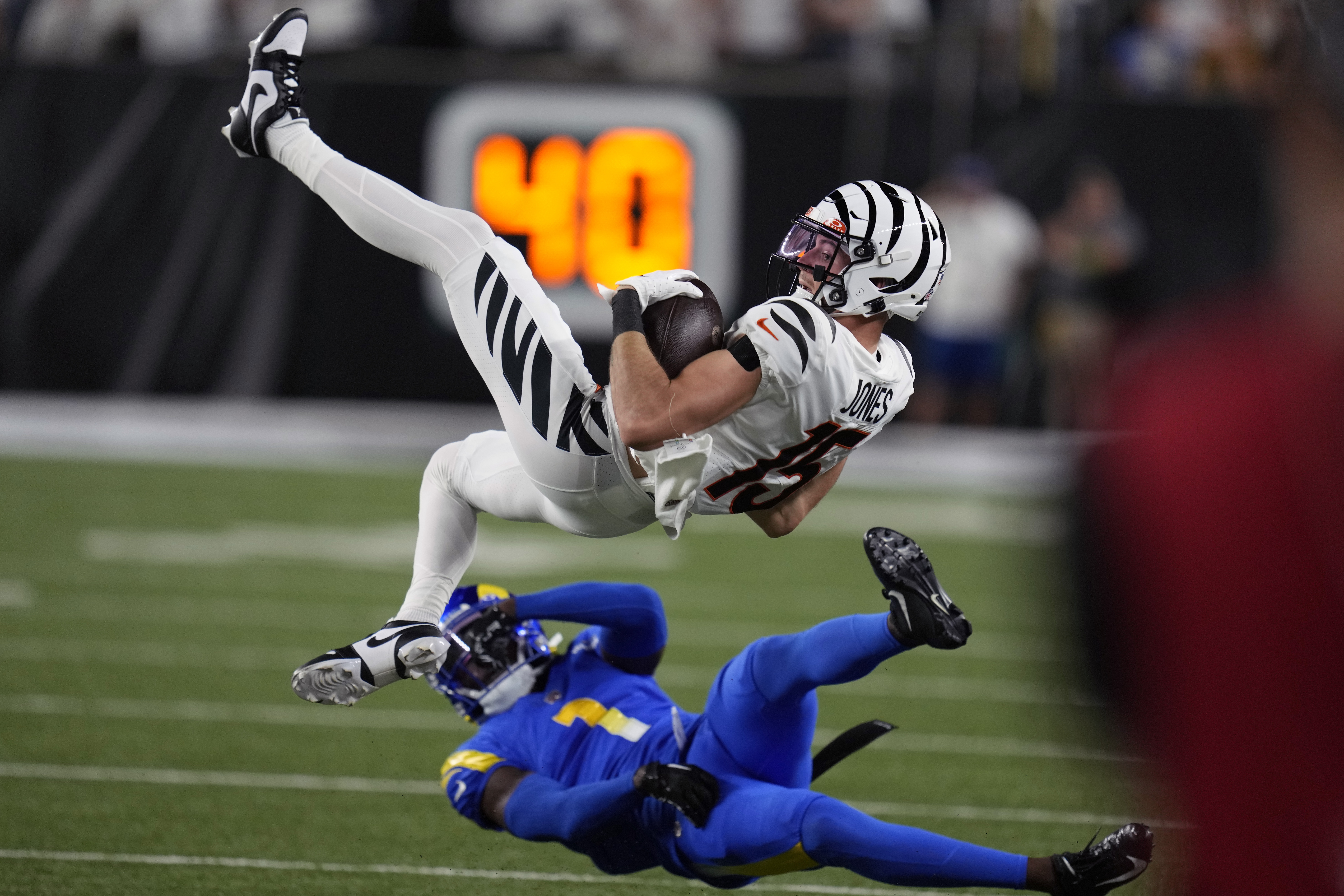 Cincinnati Bengals wide receiver Charlie Jones (15) is upended by Los Angeles Rams defensive back Derion Kendrick (1) during the first half of an NFL football game Monday, Sept. 25, 2023, in Cincinnati. 