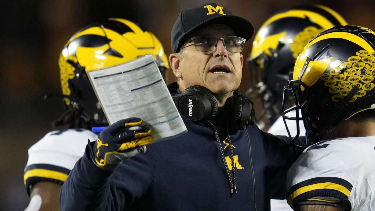 FILE - Michigan head coach Jim Harbaugh stands on the field during the first half of an NCAA college football game against Minnesota Saturday, Oct. 7, 2023, in Minneapolis. The NCAA banned in-person advanced scouting in 1994 in part because not every school could afford to do it. Now Michigan is being investigated by the NCAA for a sign-stealing scheme that allegedly involved people secretly being sent to record opponents’ games. No. 2 Michigan and the Big Ten acknowledged the investigation Thursday, Oct. 19, 2023.